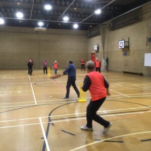 people playing walking cricket in a sports hall