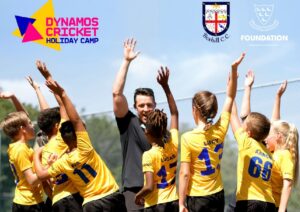 younf people in yellow t-shirts stand in fron of a coach with their hands in the air